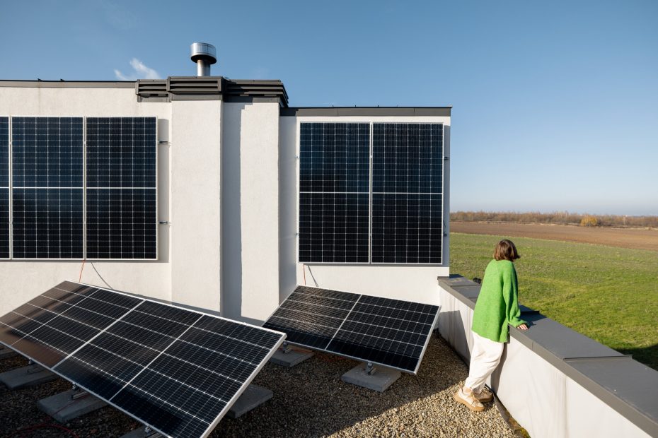 Frau auf Terasse mit eigener Photovoltaikanlage